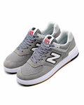 Cette chaussure est la New Balance Numeric 574 Vulc (référence couleur Grey/White), modèle classique iconique de la marque américaine New Balance