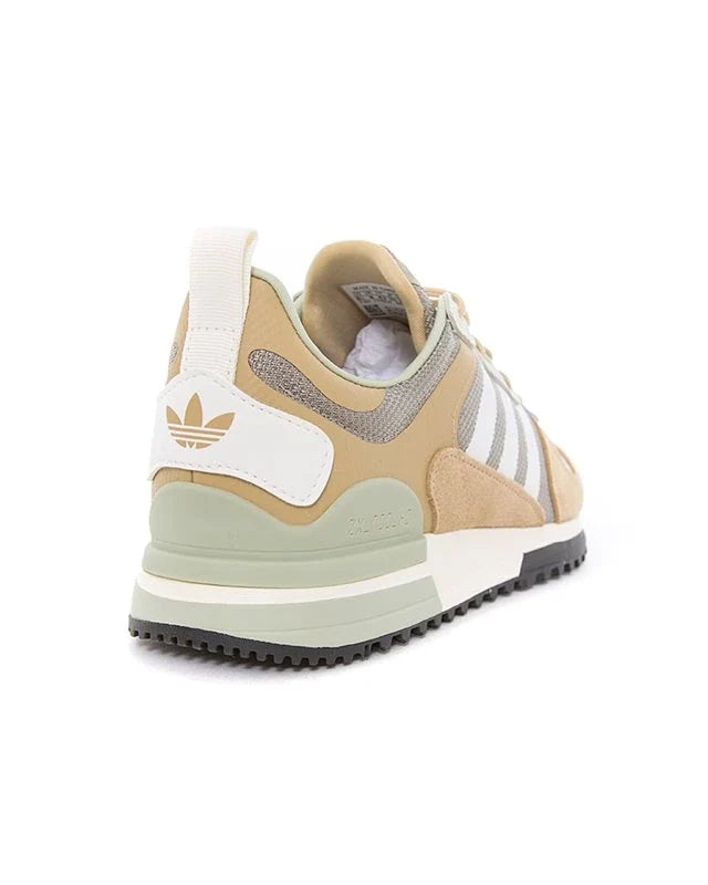 Le modèle présenté dans l'image est la adidas ZX 700 HD dans son coloris bleu marine classique avec les trois bandes blanches caractéristiques de la marque adidas.