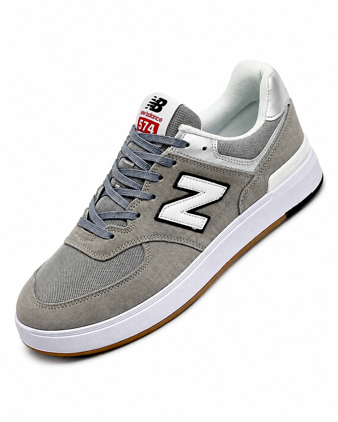 Cette chaussure est la New Balance Numeric 574 Vulc (référence couleur Grey/White), modèle classique iconique de la marque américaine New Balance